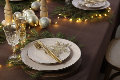 Photo of Table setting with festive lights and Christmas decor