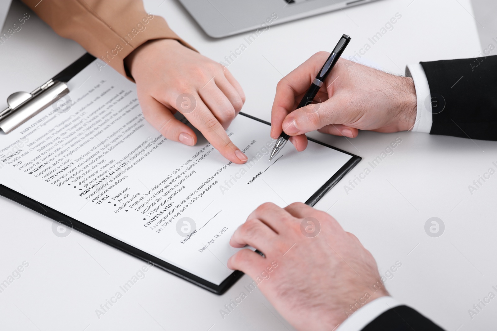 Photo of Businesspeople signing contract at white table, closeup of hands