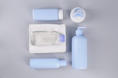Photo of Different skin care products for baby and towel on light grey background, flat lay. Space for text