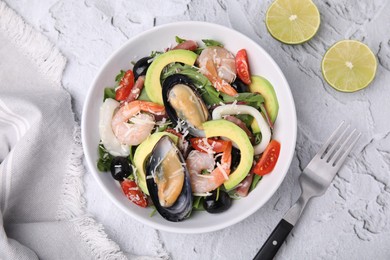 Bowl of delicious salad with seafood on white textured table, flat lay