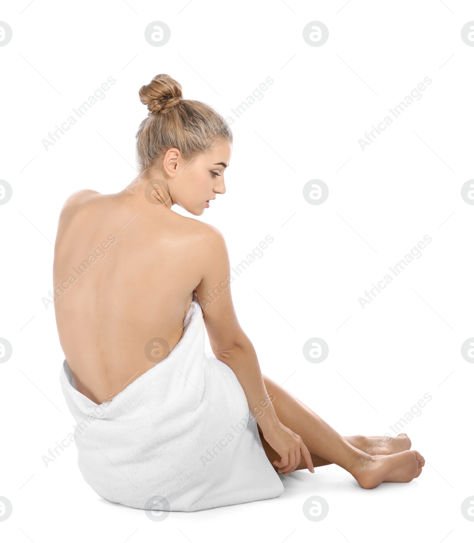 Photo of Young woman with soft towel sitting on white background