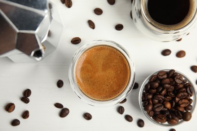 Photo of Tasty coffee and beans on white wooden table, flat lay