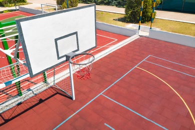 Image of Basketball backboard over football gat at outdoor sports complex on sunny day
