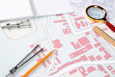 Photo of Office stationery on cadastral maps of territory with buildings