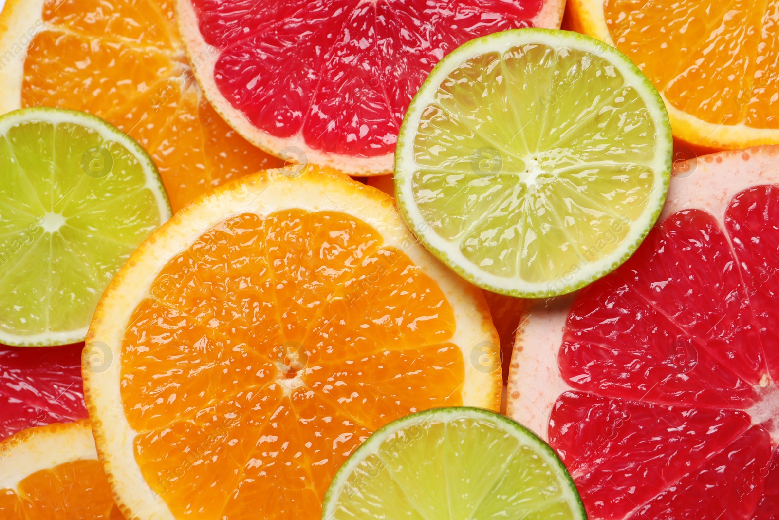 Photo of Slices of different citrus fruits as background, top view