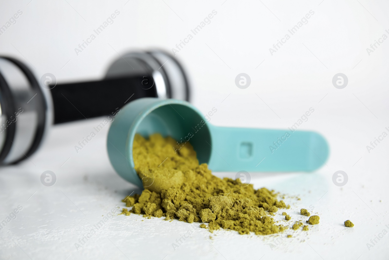 Photo of Measuring scoop with hemp protein powder on white table