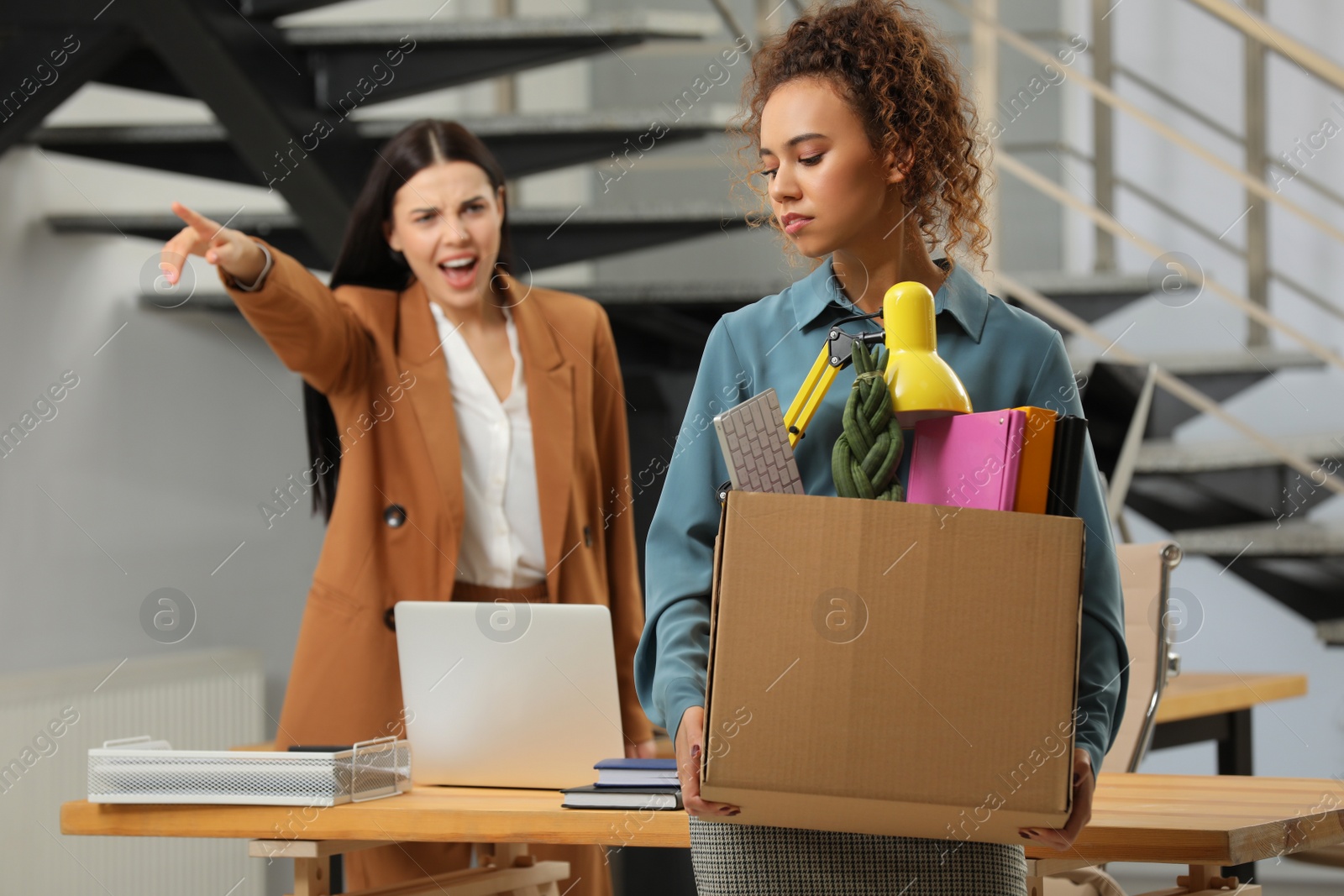 Photo of Boss dismissing young woman from work in office