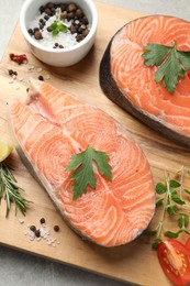 Photo of Fresh salmon and ingredients for marinade on wooden board, above view