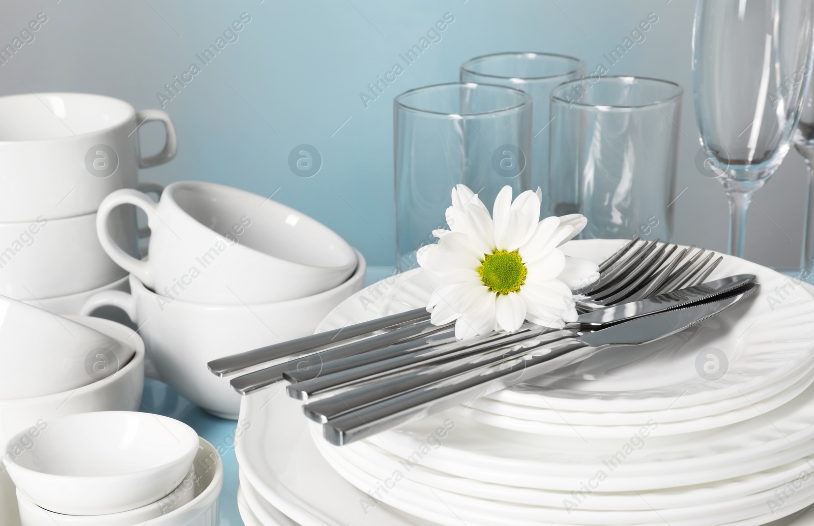 Photo of Set of clean dishes, glasses and cutlery on table, closeup