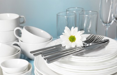 Set of clean dishes, glasses and cutlery on table, closeup