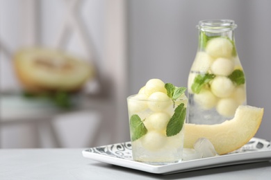 Tasty melon ball drink on grey table indoors. Space for text