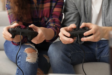 Young couple playing video games at home, closeup