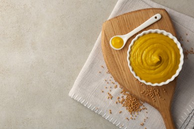 Photo of Tasty mustard sauce and dry seeds on light textured table, flat lay. Space for text