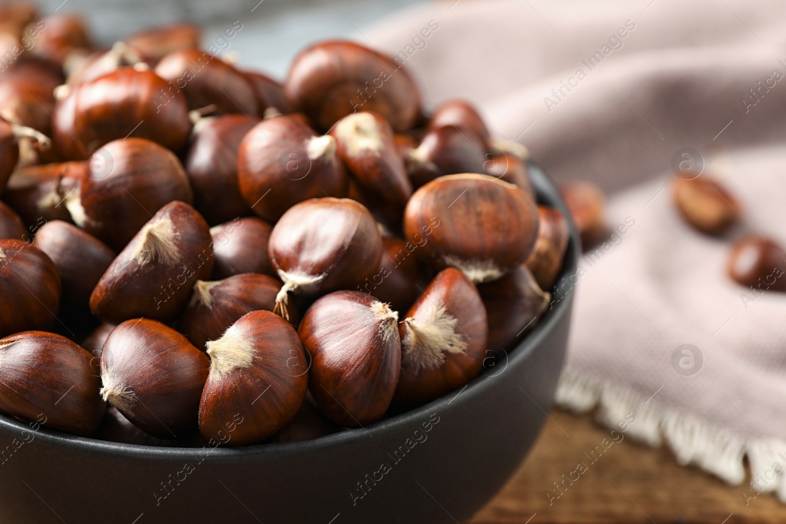 Photo of Fresh sweet edible chestnuts on table, closeup
