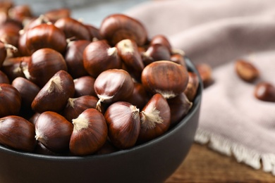 Photo of Fresh sweet edible chestnuts on table, closeup