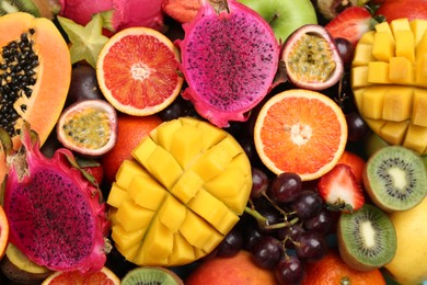 Photo of Many different delicious exotic fruits as background, top view