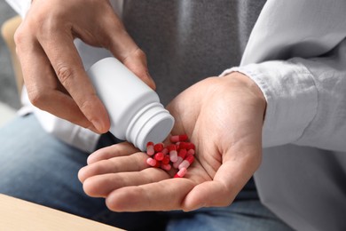 Man pouring pills from bottle, closeup view