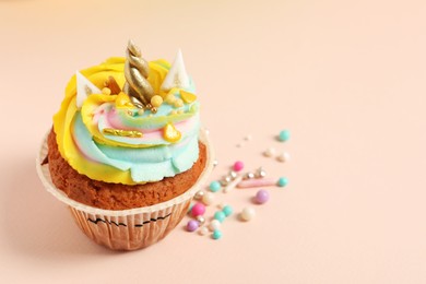 Photo of Cute sweet unicorn cupcake on beige background. Space for text
