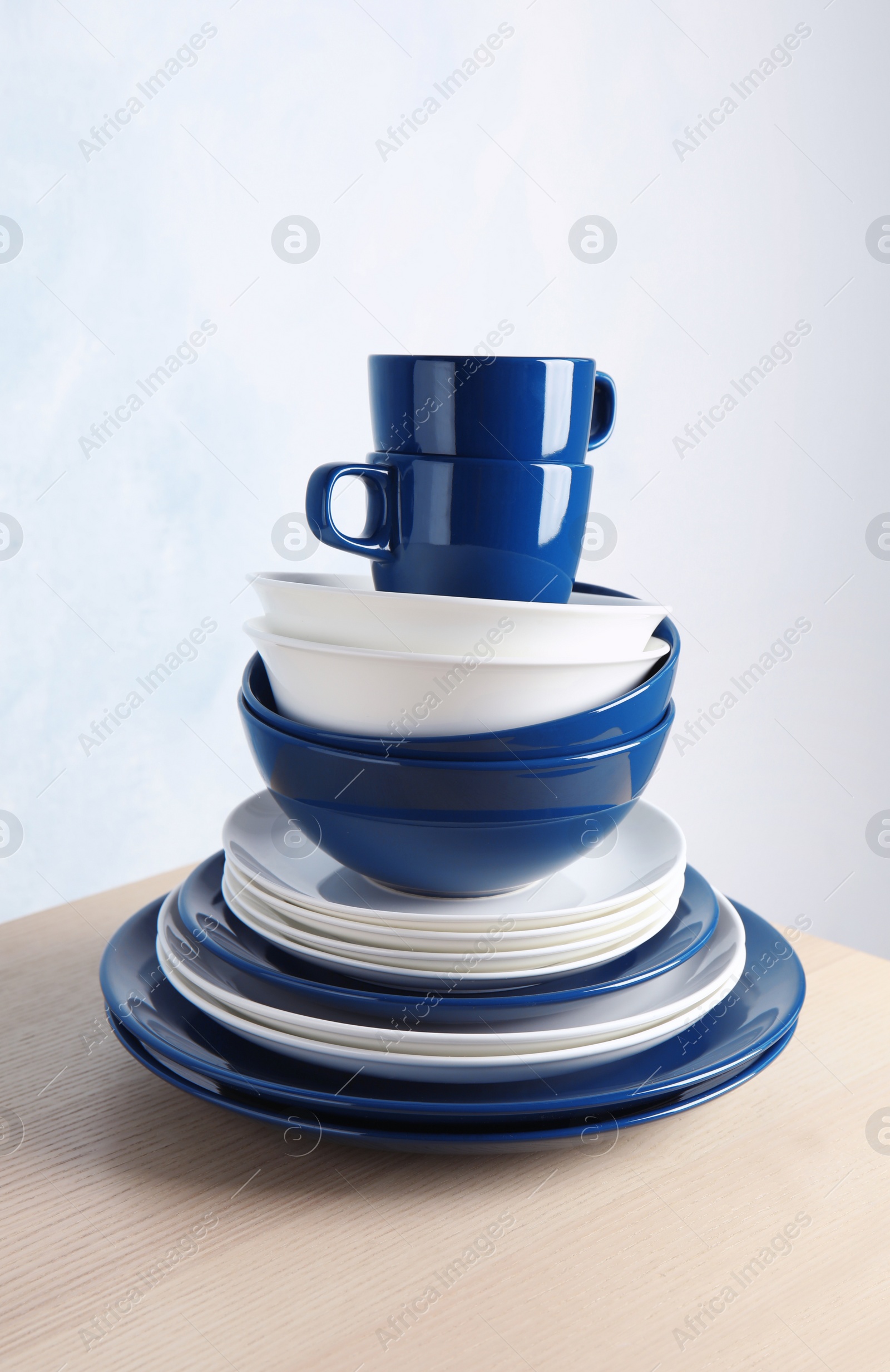 Photo of Set of dinnerware on table against light background. Interior element