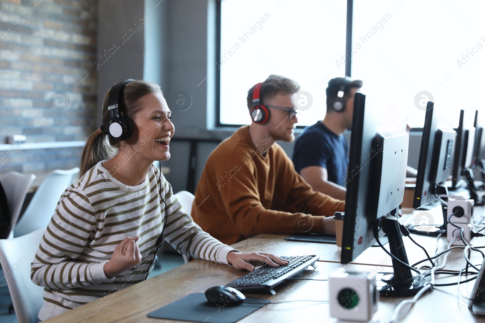 Photo of Group of people playing video games in internet cafe