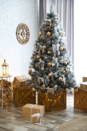 Stylish interior with decorated Christmas tree in living room