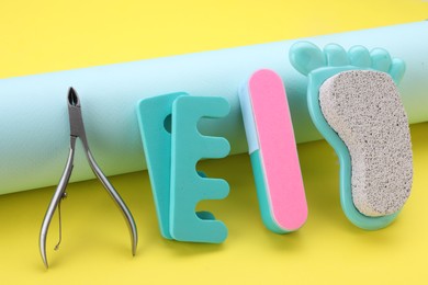 Photo of Set of pedicure tools on yellow background
