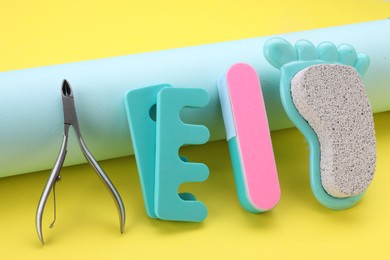 Set of pedicure tools on yellow background