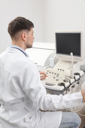 Sonographer operating modern ultrasound machine in clinic