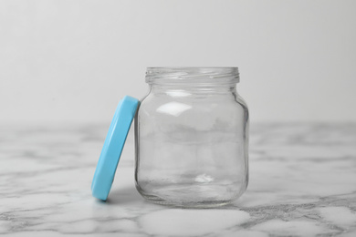Photo of Empty glass jar on white marble table