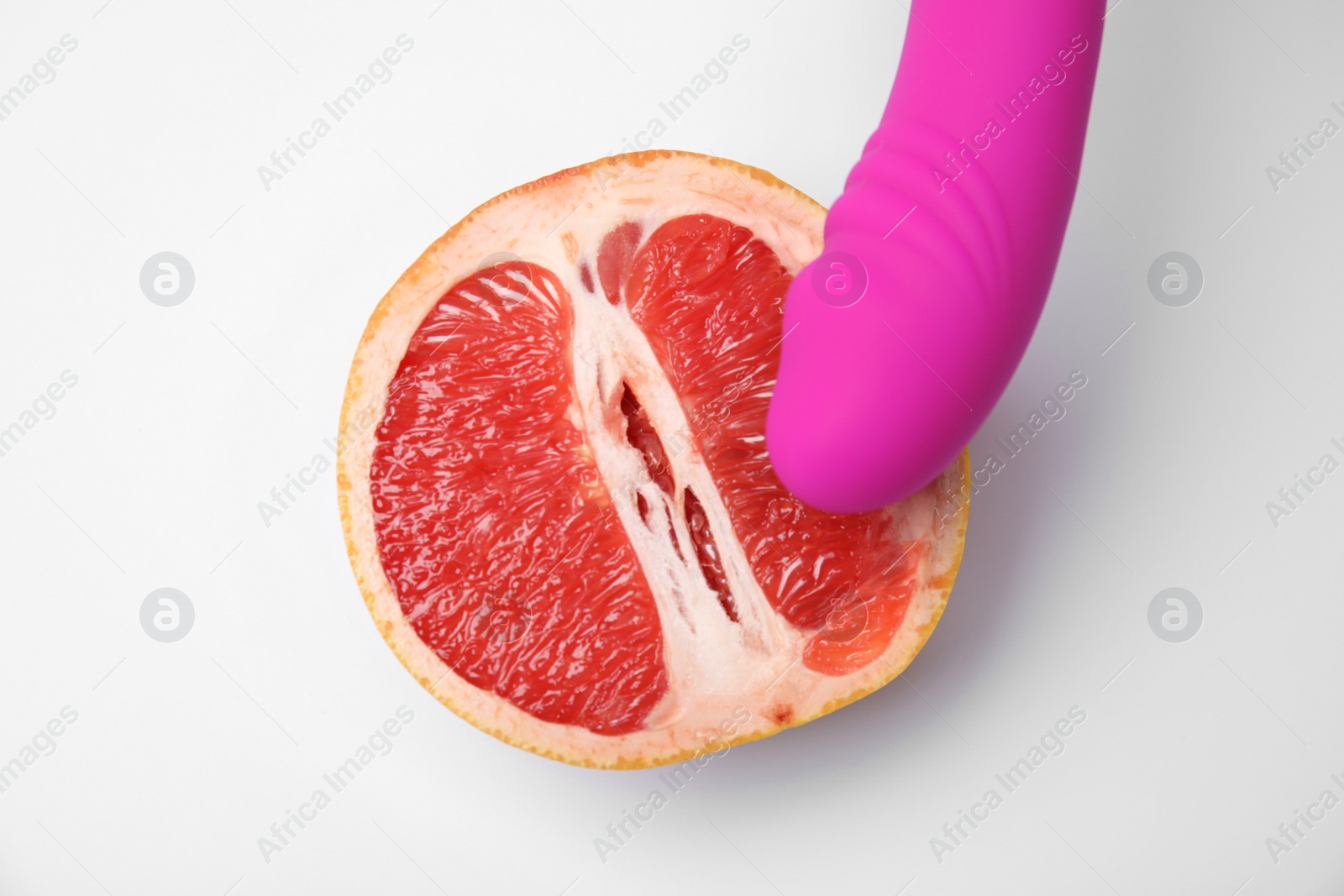 Photo of Half of grapefruit and purple vibrator on white background, top view. Sex concept