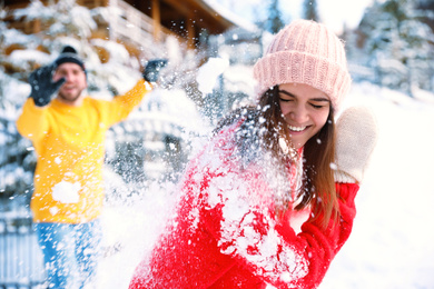 Photo of Happy couple playing snowballs outdoors. Winter vacation