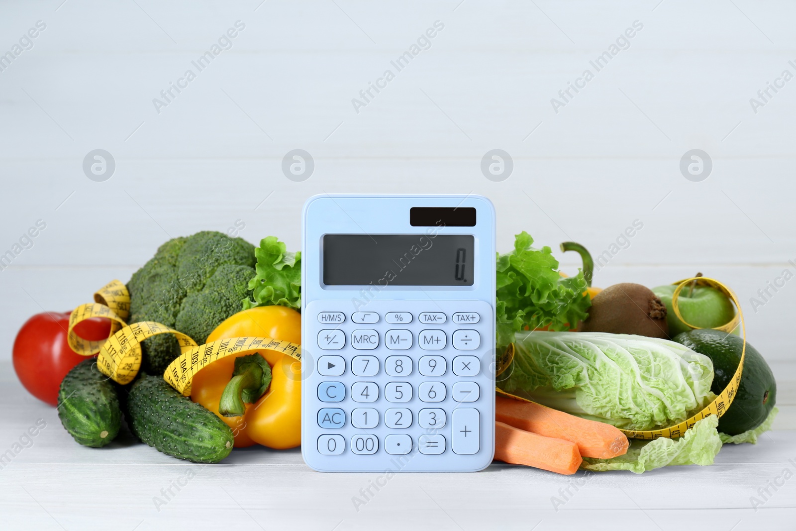 Photo of Calculator and food products on white wooden table. Weight loss concept