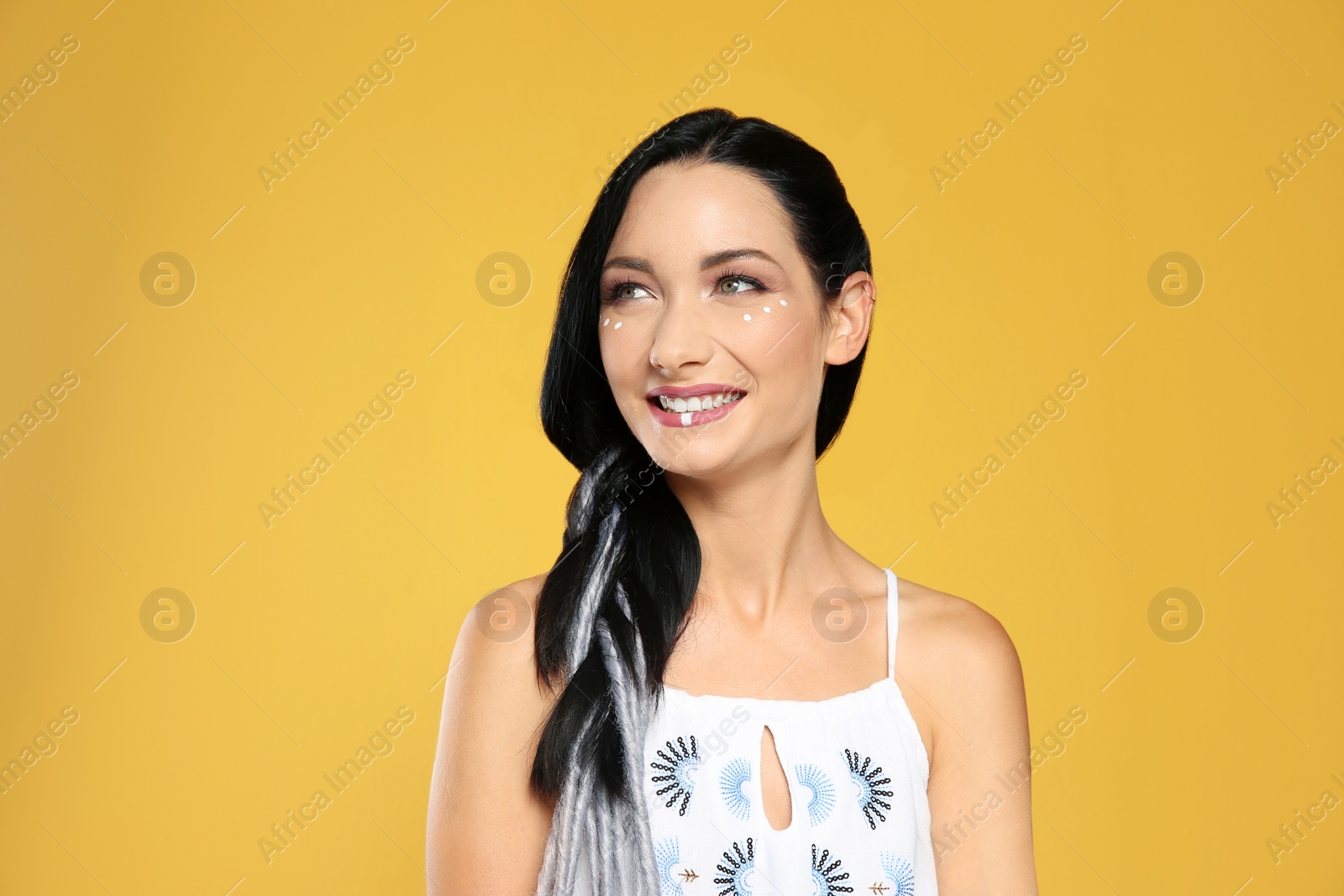 Photo of Portrait of young hippie woman with boho makeup in stylish outfit on color background