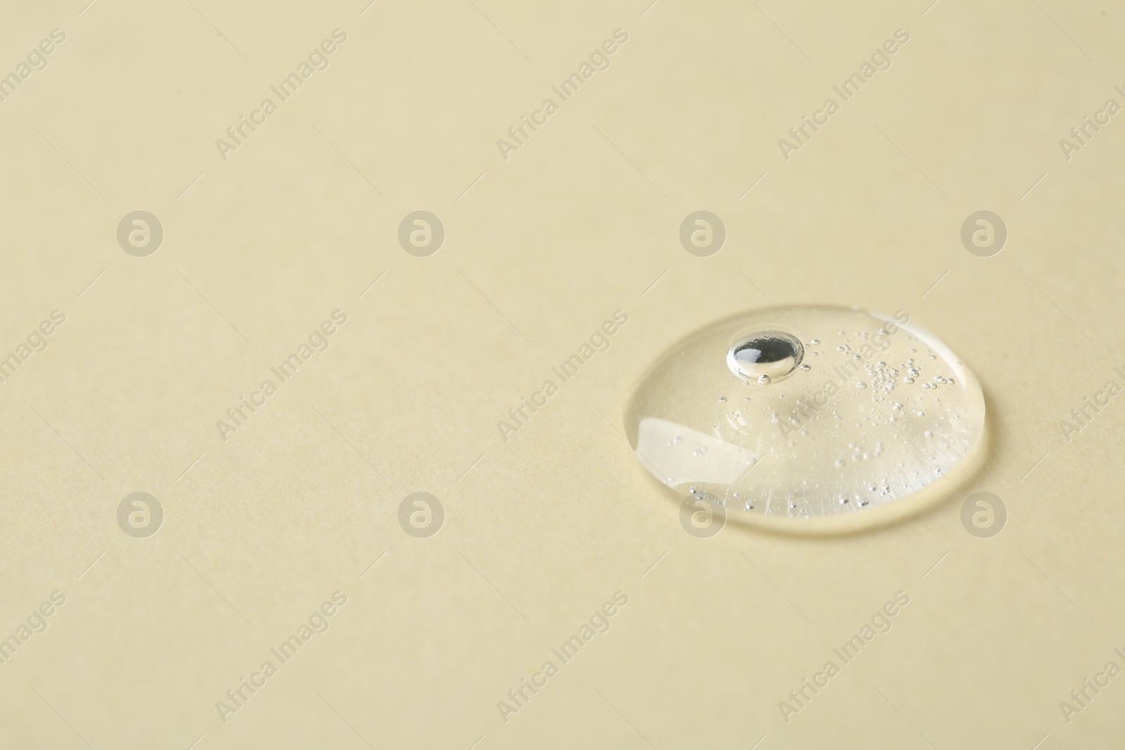 Photo of Sample of cosmetic serum on beige background, closeup. Space for text