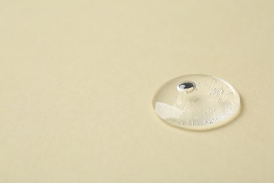 Photo of Sample of cosmetic serum on beige background, closeup. Space for text