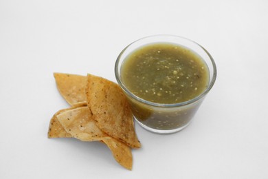 Photo of Tasty salsa sauce and tortilla chips on white background