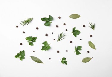 Flat lay composition with green parsley, pepper, bay leaves and rosemary on white background