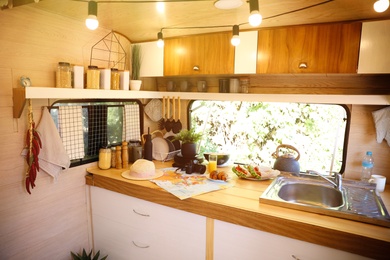 Stylish kitchen interior with different jars and utensils in modern trailer. Camping vacation