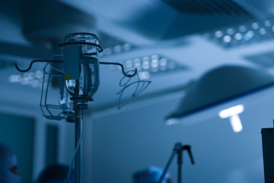 Photo of Blurred view of modern operating room, focus on rack with drugs