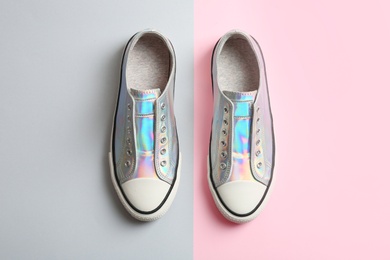 Stylish sneakers on color background, top view