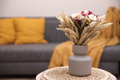 Photo of Bouquet of beautiful dry flowers and spikelets in vase on side table at home. Space for text
