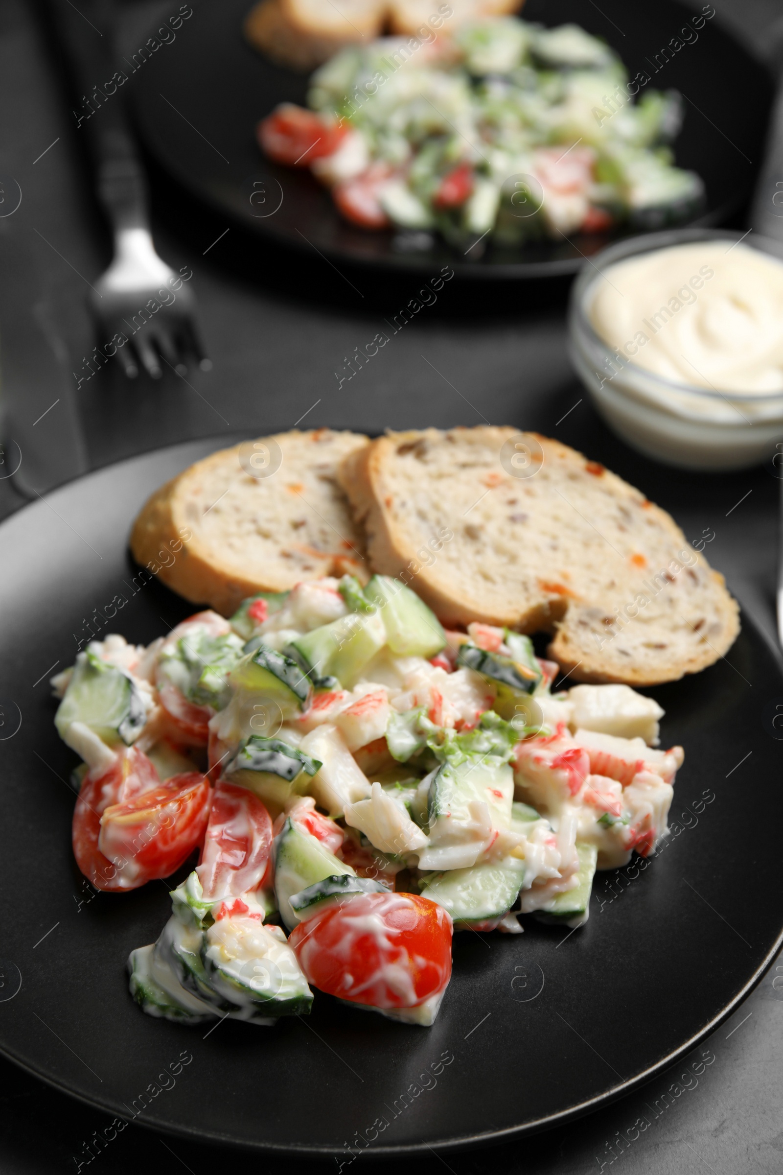 Photo of Delicious salad with mayonnaise on black table