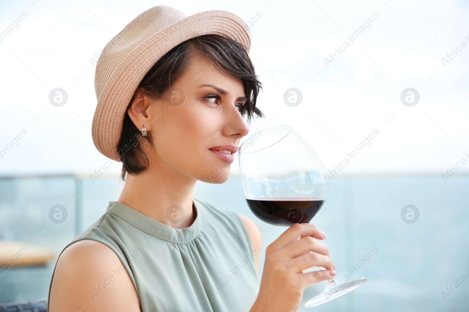 Photo of Young woman with glass of red wine outdoors