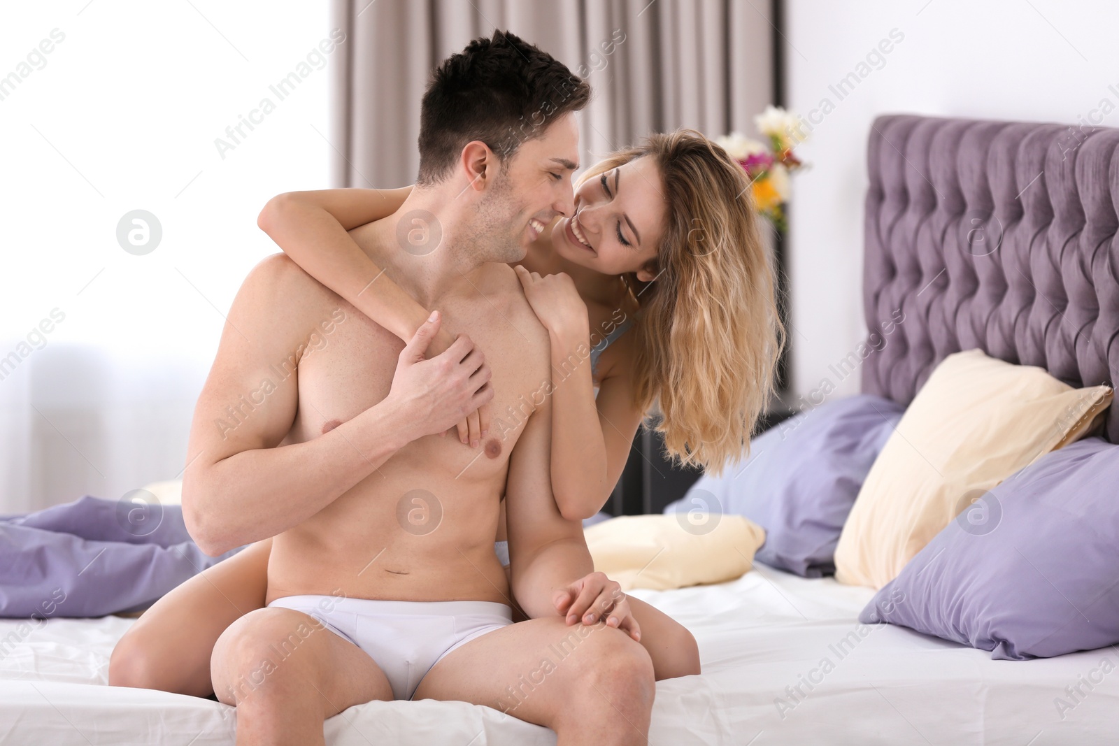 Photo of Sexy young couple being intimate on bed at home