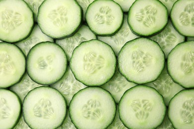 Photo of Fresh slices of cucumbers as background, top view