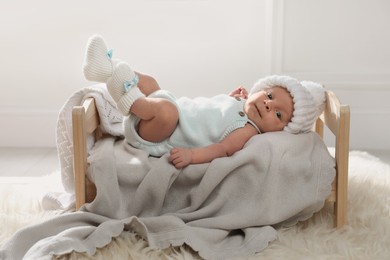 Photo of Adorable newborn baby on small wooden bed indoors