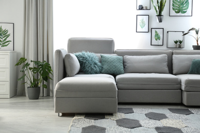 Photo of Comfortable large sofa in light room. Interior design