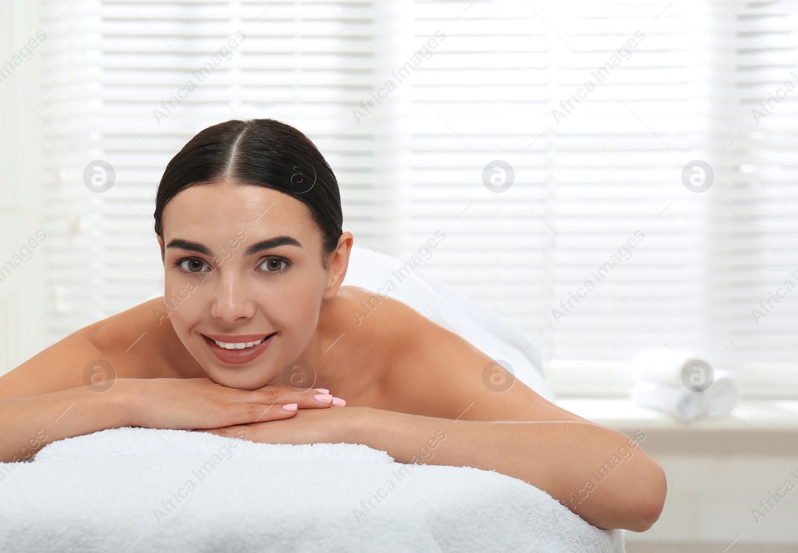 Photo of Beautiful young woman relaxing in spa salon