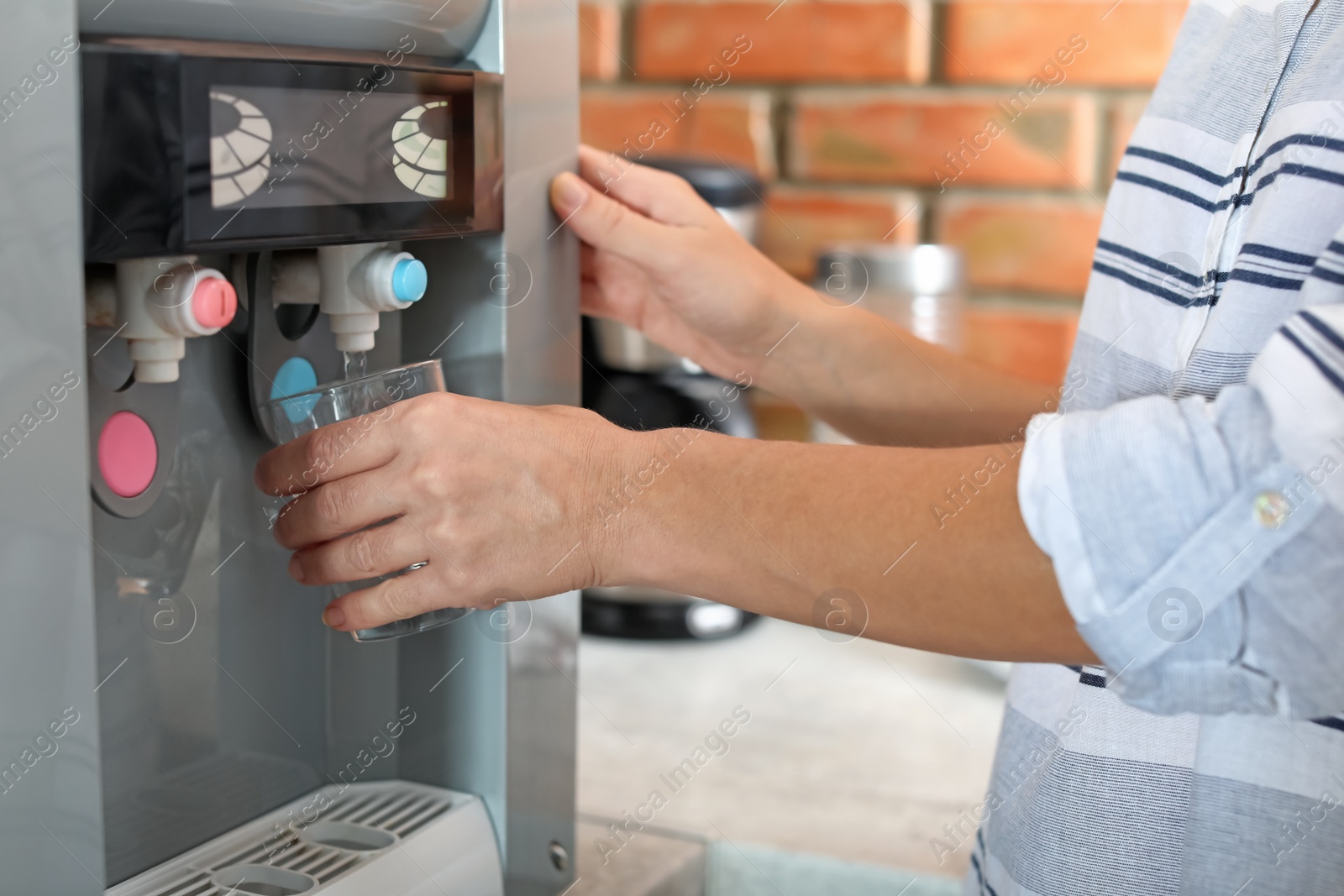 Photo of Woman filling glass with water from cooler indoors, closeup