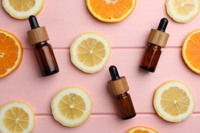 Photo of Aromatherapy. Different essential oils and citrus fruits on pink wooden table, flat lay